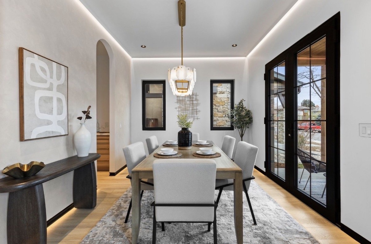 Dining room with an arched doorway, black French doors, glass pendant and cream dining chairs